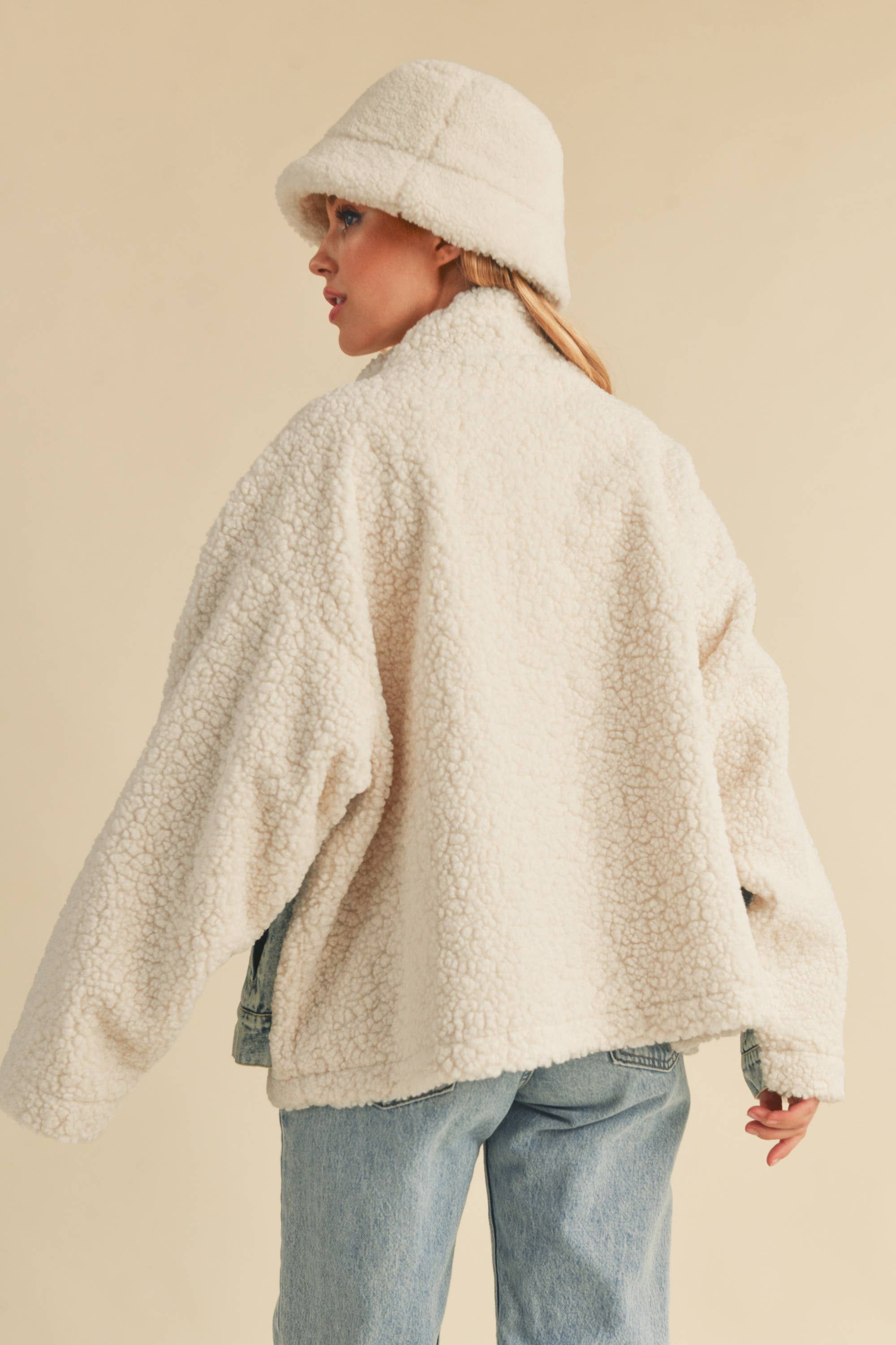 Back view of a sherpa-lined jacket paired with a fleece bucket hat.