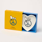 Heart-shaped trinket dish with Snoopy resting on a blue peace sign.