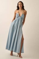 Woman wearing a light blue halter maxi dress with a plunging neckline, side slit, and flowy fit.