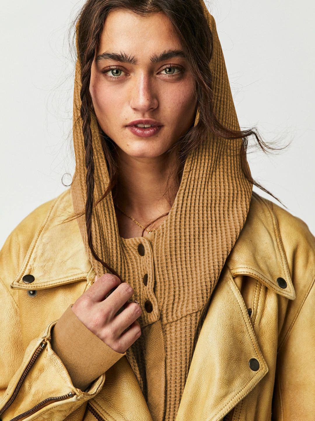 Woman wearing a Sahara Sky Hooded Jacket with a zip-up front, textured waffle knit, and button detailing in blue and brown tones.