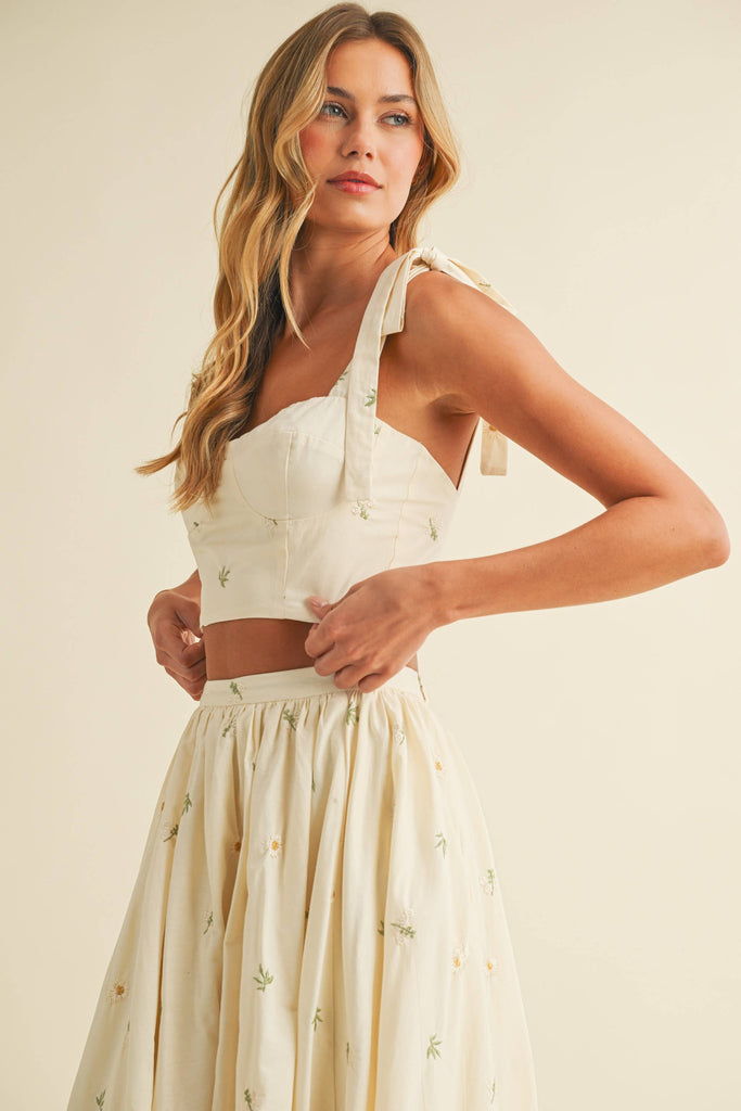 Light cream two-piece set with small floral embroidery, featuring bow-tie strap top and flowy maxi skirt