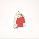 Snoopy and Woodstock ceramic coin bank with Snoopy lying on his red doghouse.