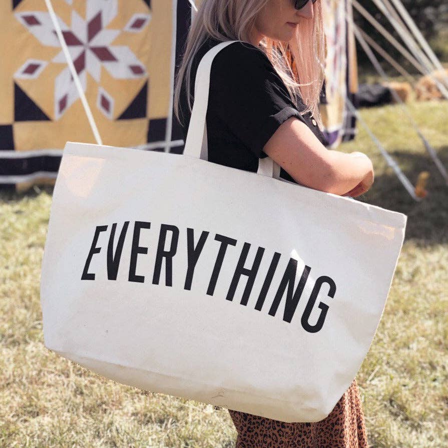 Coral tote bag with “Sunshine Appreciation Society” in white lettering, carried by a woman in a rust-colored embroidered dress