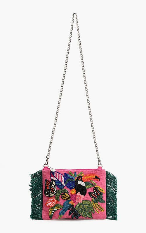 Pink beaded clutch with toucan, butterfly, and tropical floral embroidery, green fringe sides, and silver chain strap.
