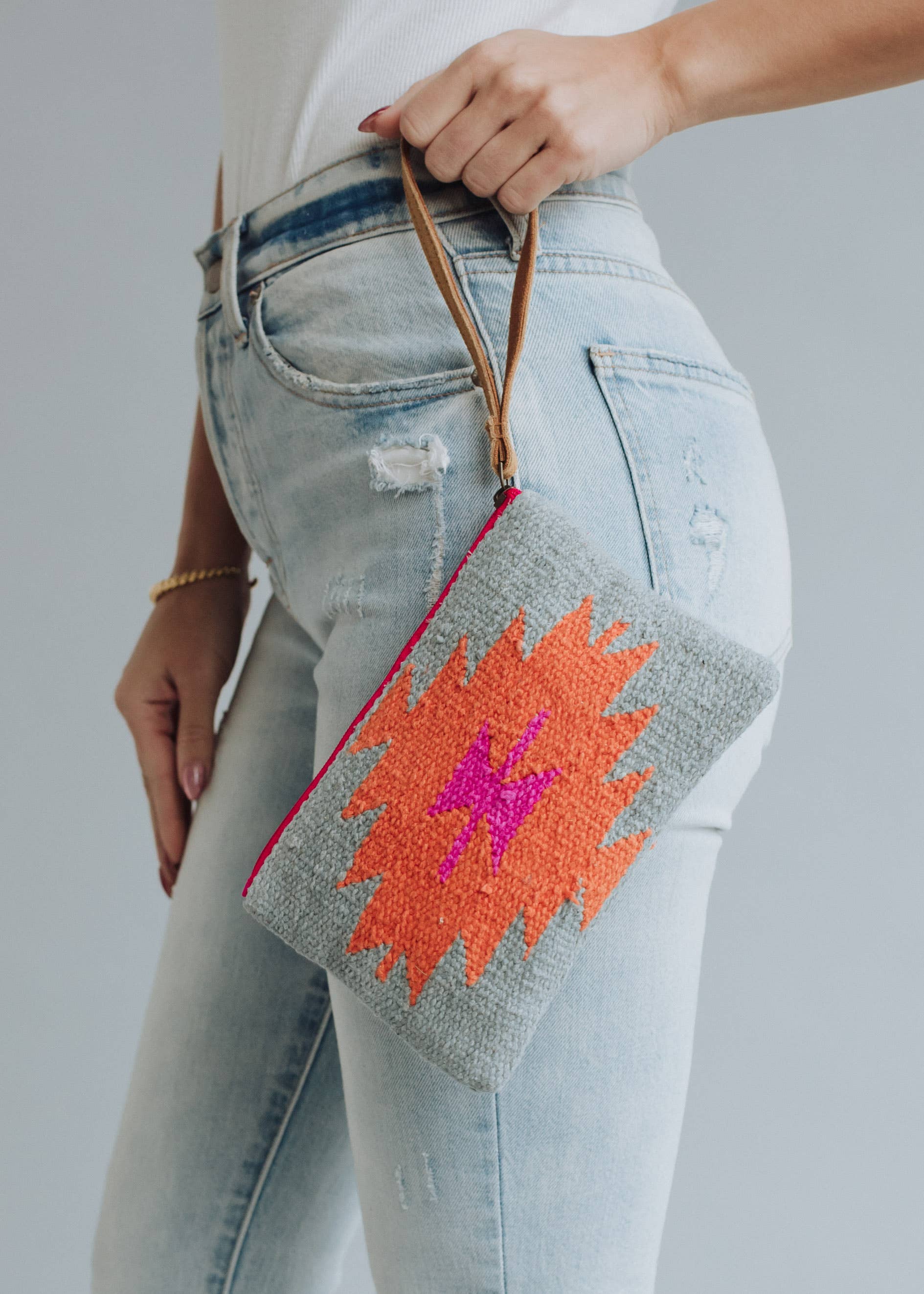 Woven wristlet pouch with gray background and bright orange and magenta lightning bolt design
