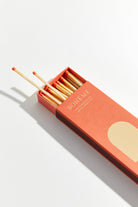 Matchbox with matches extended on a light background