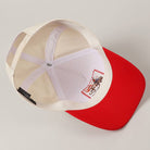 Baseball cap with red brim and beige back on a light gray background