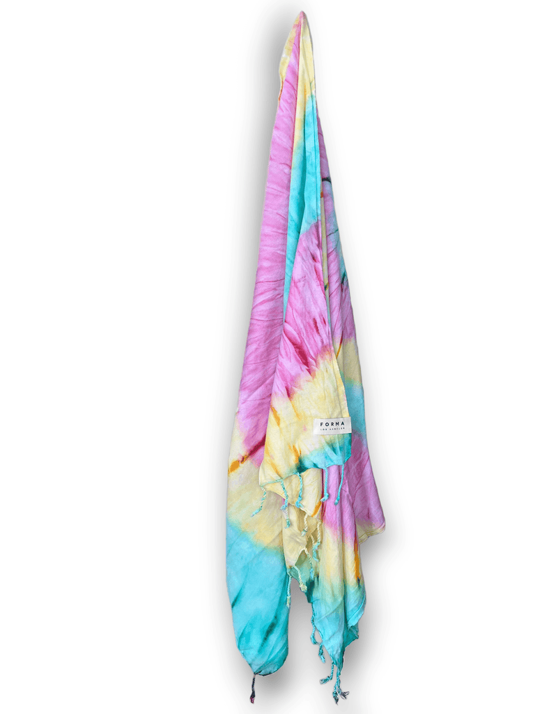 A colorful set of Forma Towels from the Aura Collection, displayed as beach towels, home towels, and a shawl.