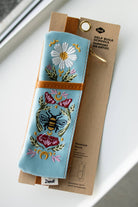 Honeybee Tea embroidered pouch with floral design on soft faux suede, featuring an elastic band that fits around most notebooks.
