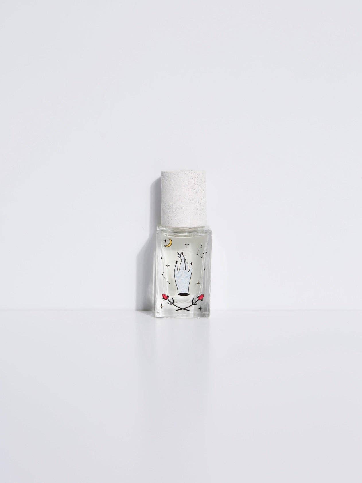 Maison Matine Avant l’Orage perfume bottle with celestial illustrations, placed among citrus fruits and sample vials on blue fabric