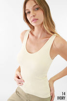 Woman wearing the Eclipse Ribbed Tank Top in ivory, featuring a snug fit and ribbed fabric for a flattering silhouette.