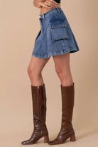 A-line utility denim skirt with large side pockets and button detail, paired with a black crop top.