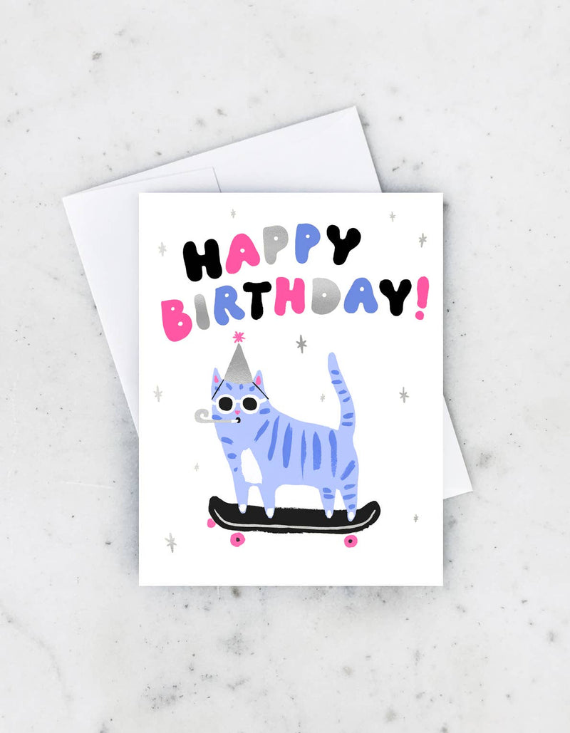 Birthday card with a blue cat wearing sunglasses and a party hat, riding a skateboard under “Happy Birthday” text.