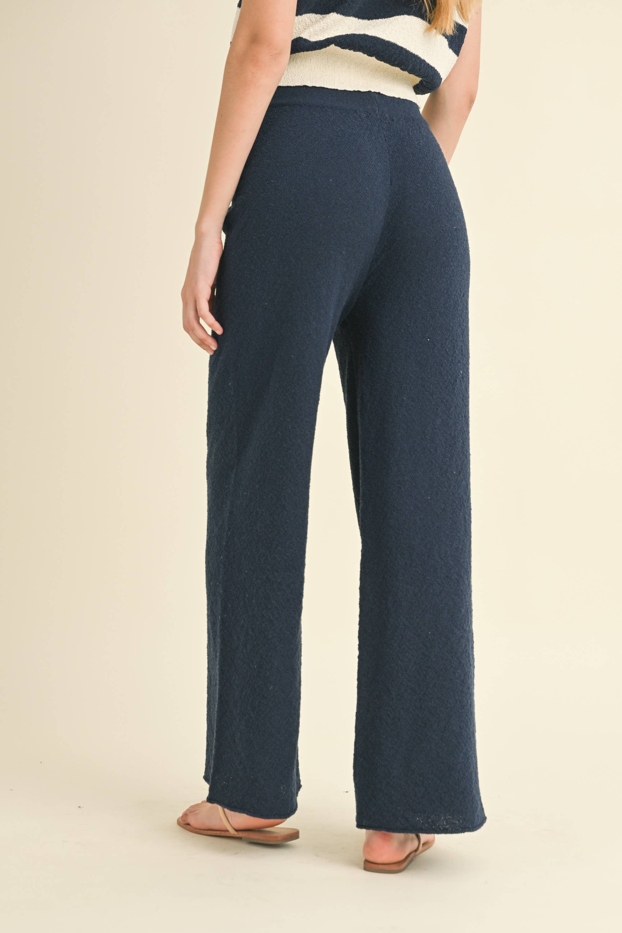 Model wearing navy blue knit wide-leg pants with a relaxed fit and soft texture.