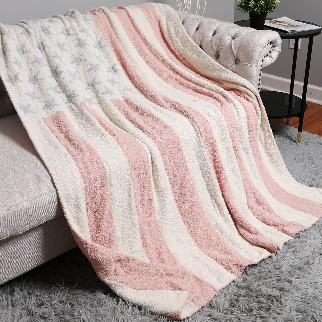 Pink and white striped blanket draped over a sofa in a living room setting.