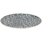 Round ceramic plate with blue leaf pattern on a white background