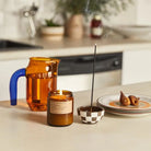 Elegant Black Fig Soy Candle in a glass container, flickering with a warm and soothing glow.