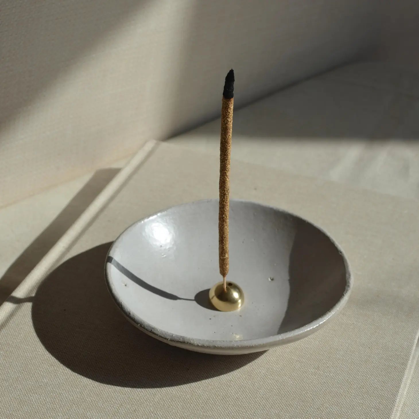 A stylish Brass Arch Incense Holder on a sleek backdrop, exuding modern elegance, designed to hold incense effortlessly.