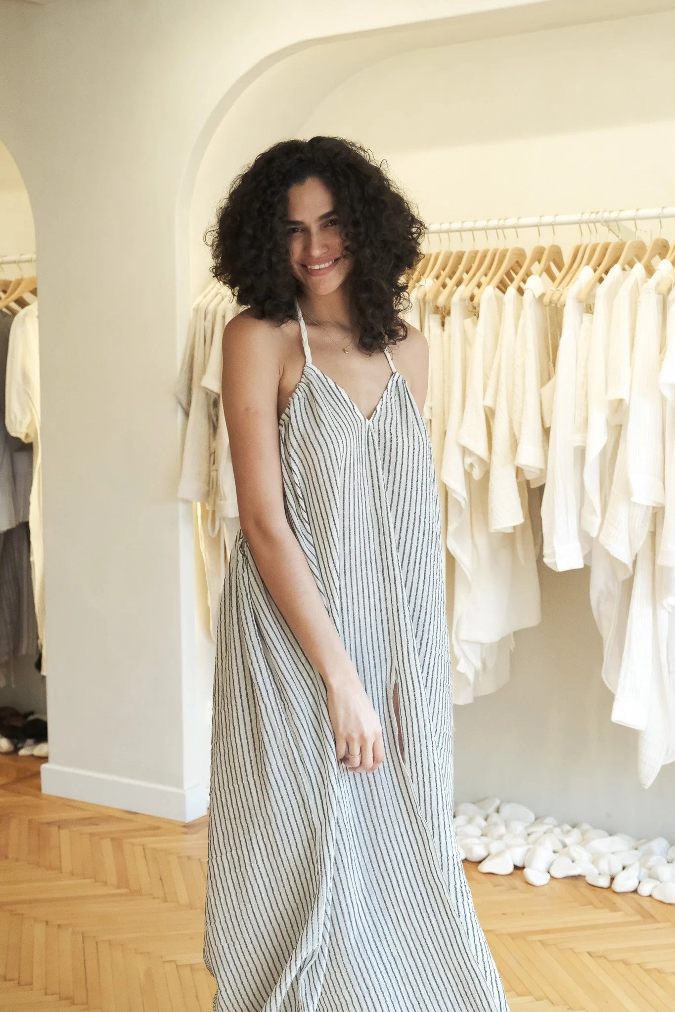 A woman wearing the Breeze Beach Dress, showcasing its relaxed and flowy silhouette, adjustable straps, and vibrant colors, perfect for a beach getaway.