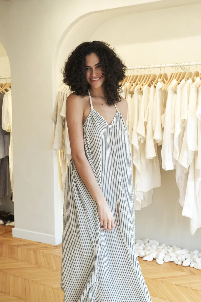 A woman wearing the Breeze Beach Dress, showcasing its relaxed and flowy silhouette, adjustable straps, and vibrant colors, perfect for a beach getaway.