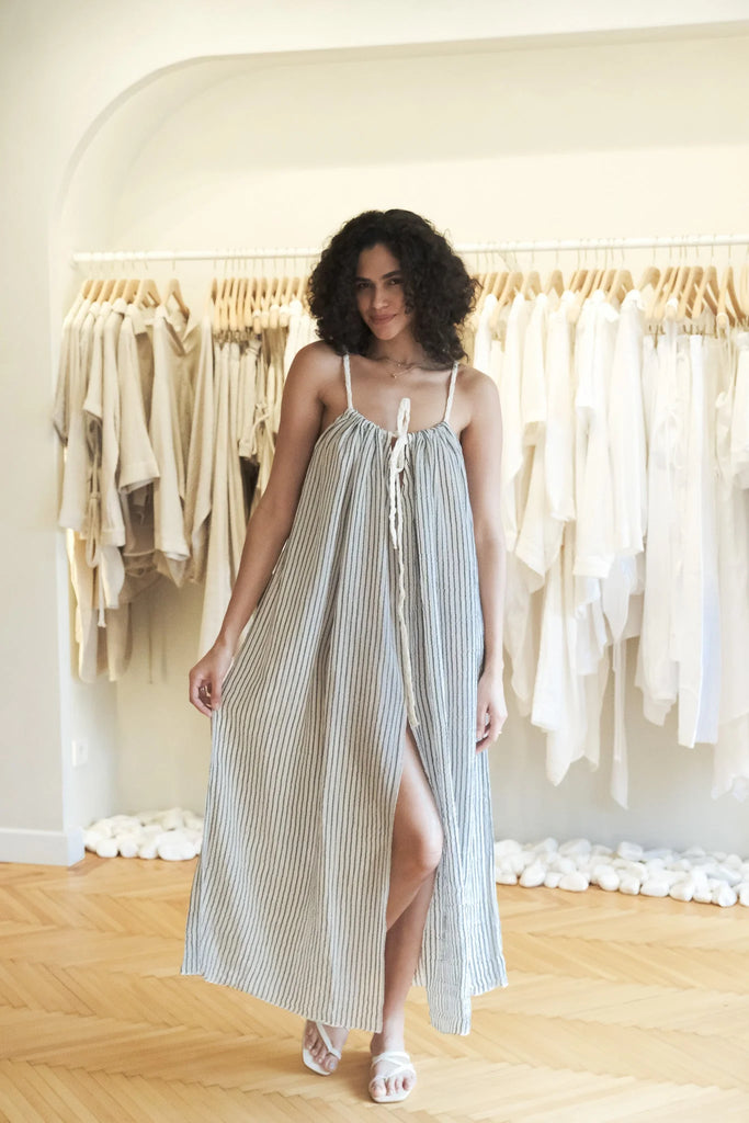 A woman wearing the Breeze Beach Dress, showcasing its relaxed and flowy silhouette, adjustable straps, and vibrant colors, perfect for a beach getaway.