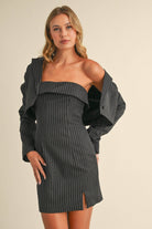 Woman wearing a black pinstriped strapless midi dress with a matching cropped blazer jacket.