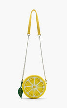 Round beaded lemon slice crossbody bag with silver chain strap and green leaf charm accent.