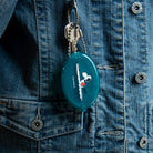 Peanuts® - Snoopy Surf Coin Pouch in teal with an illustration of Snoopy surfing on a wave, featuring a secure snap closure and attached ball chain.
