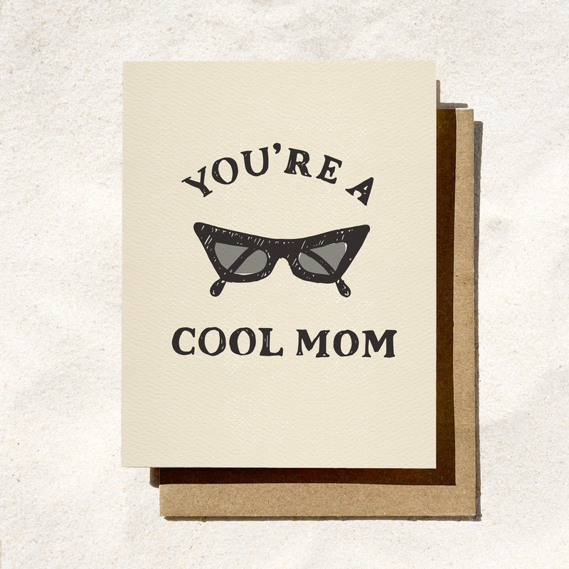Greeting card with a vintage sunglasses illustration and "You're a Cool Mom" text, set on a textured beige background.