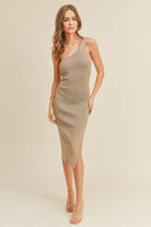 Model wearing a beige one-shoulder ribbed dress with a side slit, posing confidently.