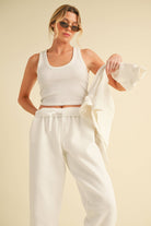 Woman wearing light heather beige fleece jogger pants with a relaxed fit and elastic waistband.