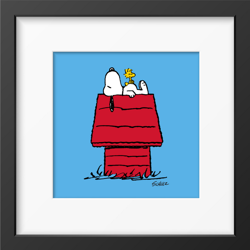 Framed print of Snoopy resting on his red doghouse with Woodstock perched beside him.