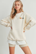 Smiley Face Embroidered Sweater with three smiley face details on the front and a larger smiley face on the back.