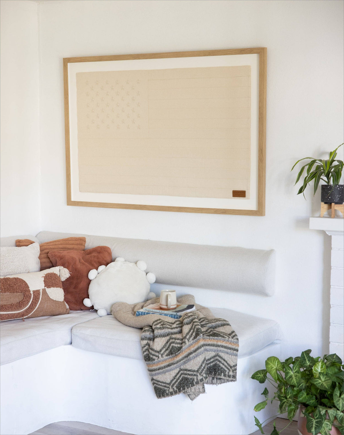 White sofa with decorative pillows and a blanket in a living room setting.