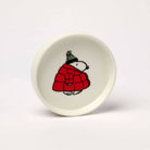 Round ceramic trinket dish featuring a black-and-white beagle wearing a red puffer jacket and green knit hat, packaged in a coordinating gift box.
