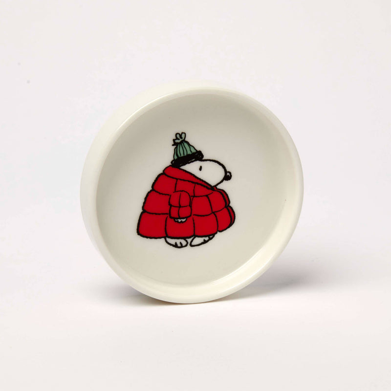 Round ceramic trinket dish featuring a black-and-white beagle wearing a red puffer jacket and green knit hat, packaged in a coordinating gift box.
