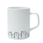 A ceramic mug with a cute cat design, filled with a warm beverage, placed on a table.