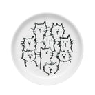 A coaster with an adorable cat-themed design placed on a wooden table.