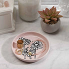 A colorful Daisy Coaster placed on a wooden table, showcasing its floral design.