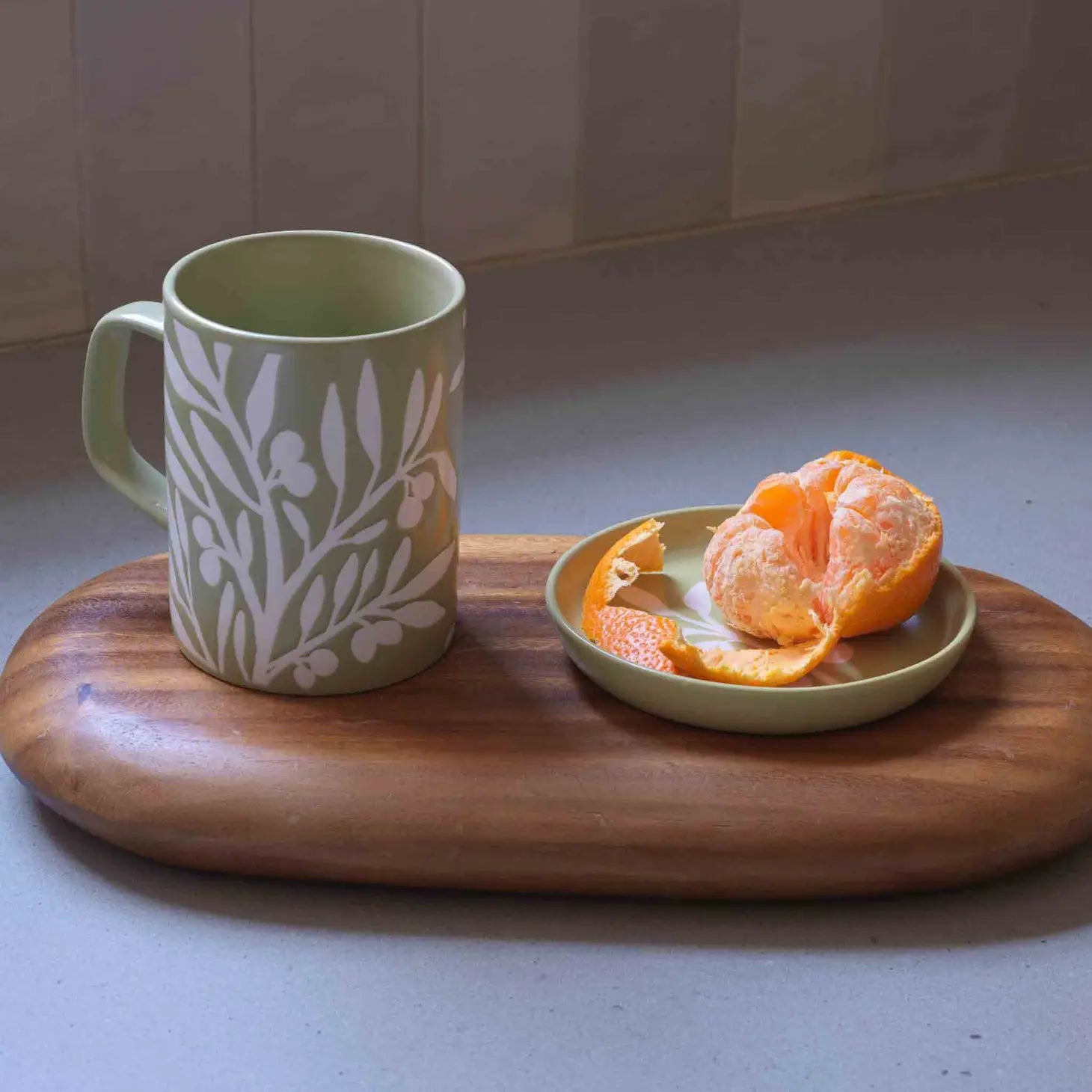 An Olive Branch Coaster with a refined design, on a wooden tabletop.
