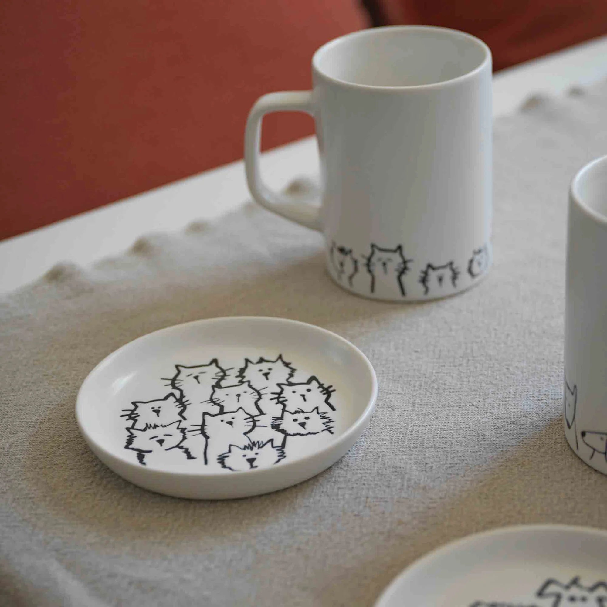 A coaster with an adorable cat-themed design placed on a wooden table.