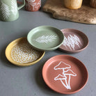 A Mushroom Coaster with a vibrant and fun design, placed on a wooden surface.