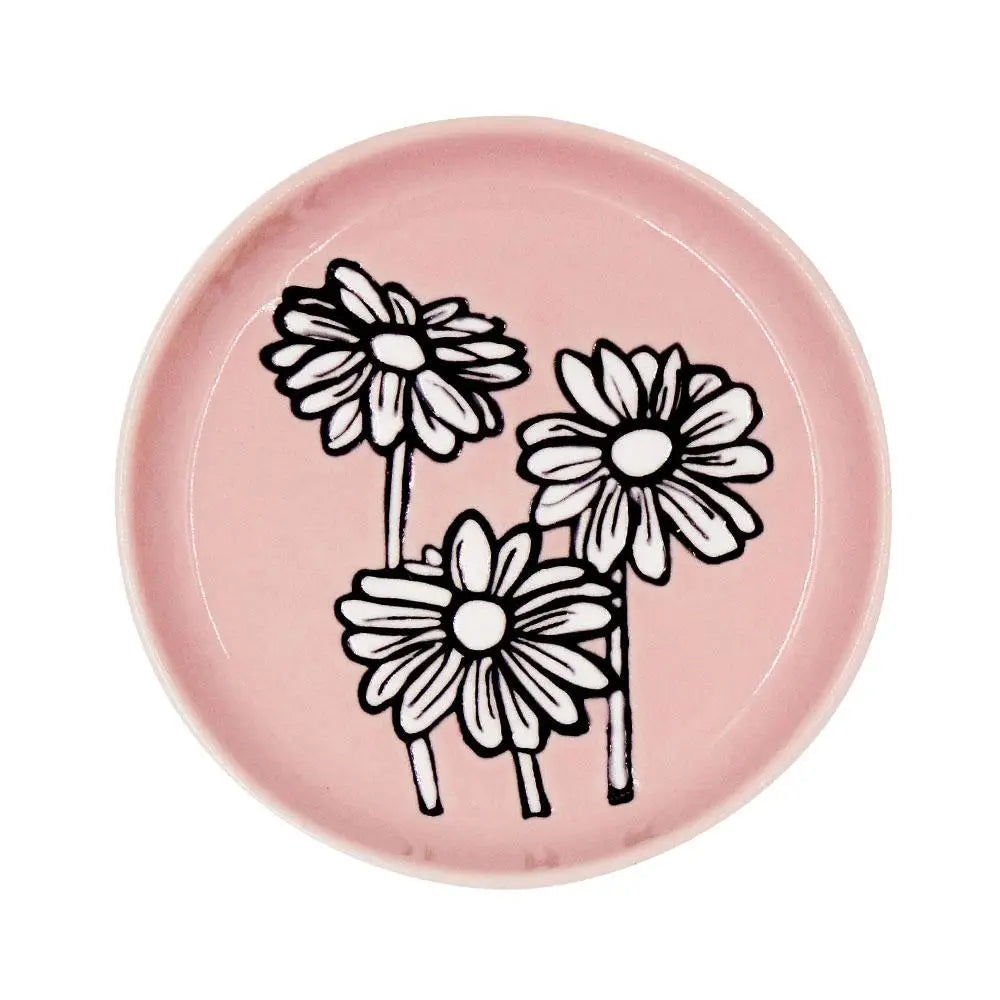 A colorful Daisy Coaster placed on a wooden table, showcasing its floral design.
