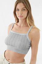 Woman elegantly modeling FORMA's Heather Vintage Chain Knit Bralette, showcasing the intricate chain details and knit pattern.