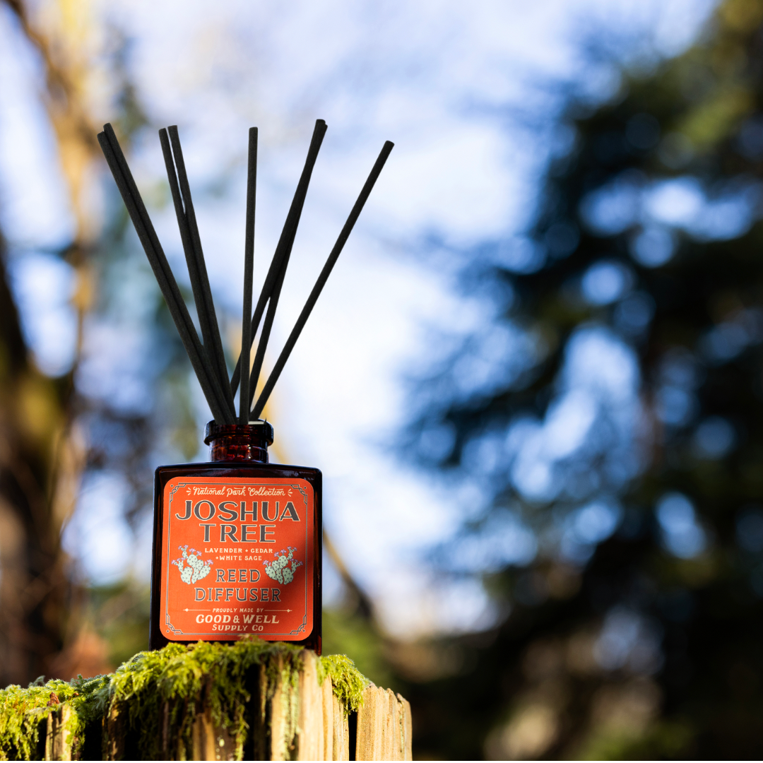 Joshua Tree reed diffuser with amber glass bottle and black reeds by Good & Well Supply Co., scented with lavender, cedar, and sage.