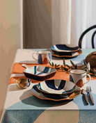 Canvas Stamped Plate with abstract mustard yellow, navy blue, and light blue patterns.