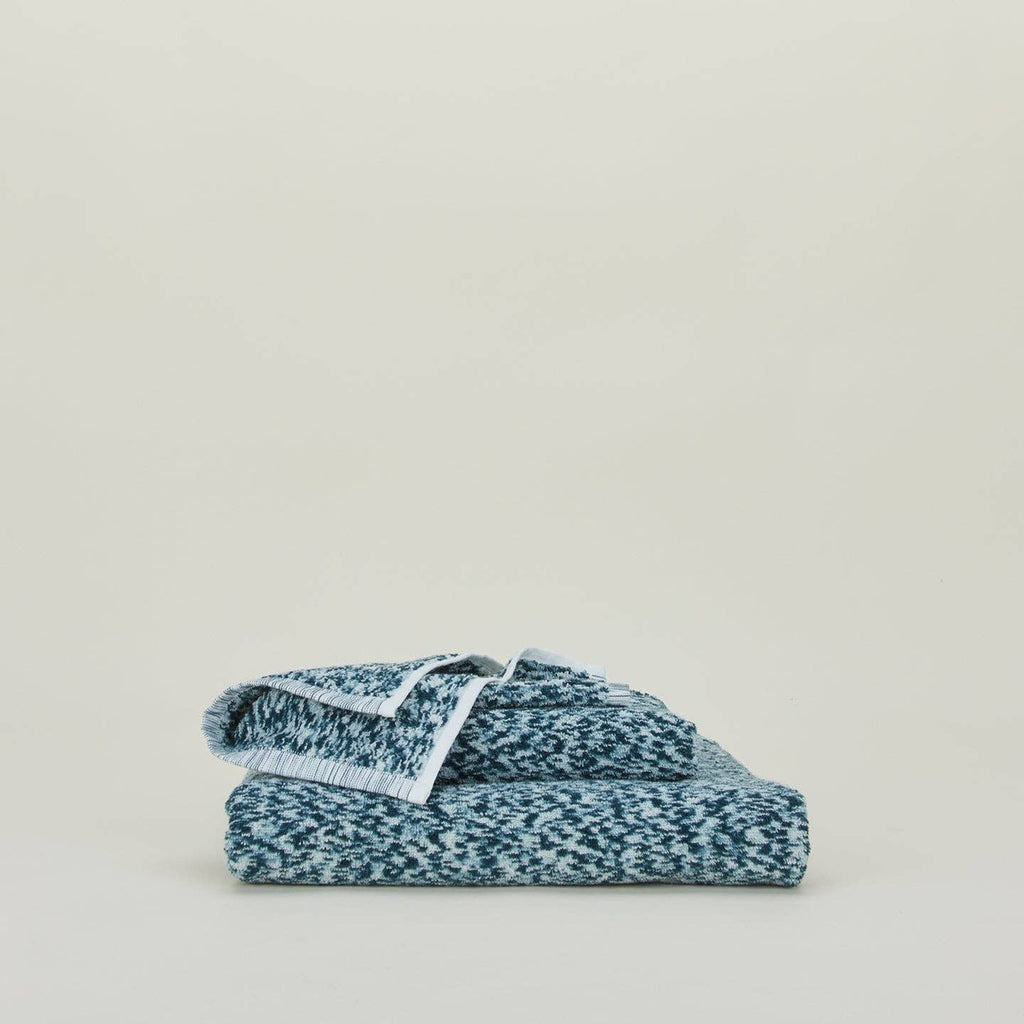 Textured cotton towel with looped terry surface and clean stitched edges, shown flat and lightly crumpled.
