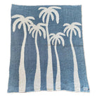 Soft chambray blue plush throw with palm tree design, perfect for cozying up or adding a beachy touch to any space.