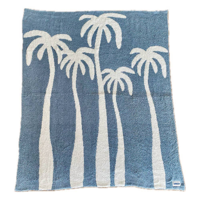 Soft chambray blue plush throw with palm tree design, perfect for cozying up or adding a beachy touch to any space.