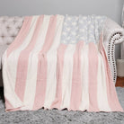 Pink and white striped blanket draped over a gray sofa.